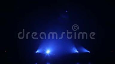 蓝色的光线在黑暗中交替地在舞台上闪现。 空的音乐会舞台。